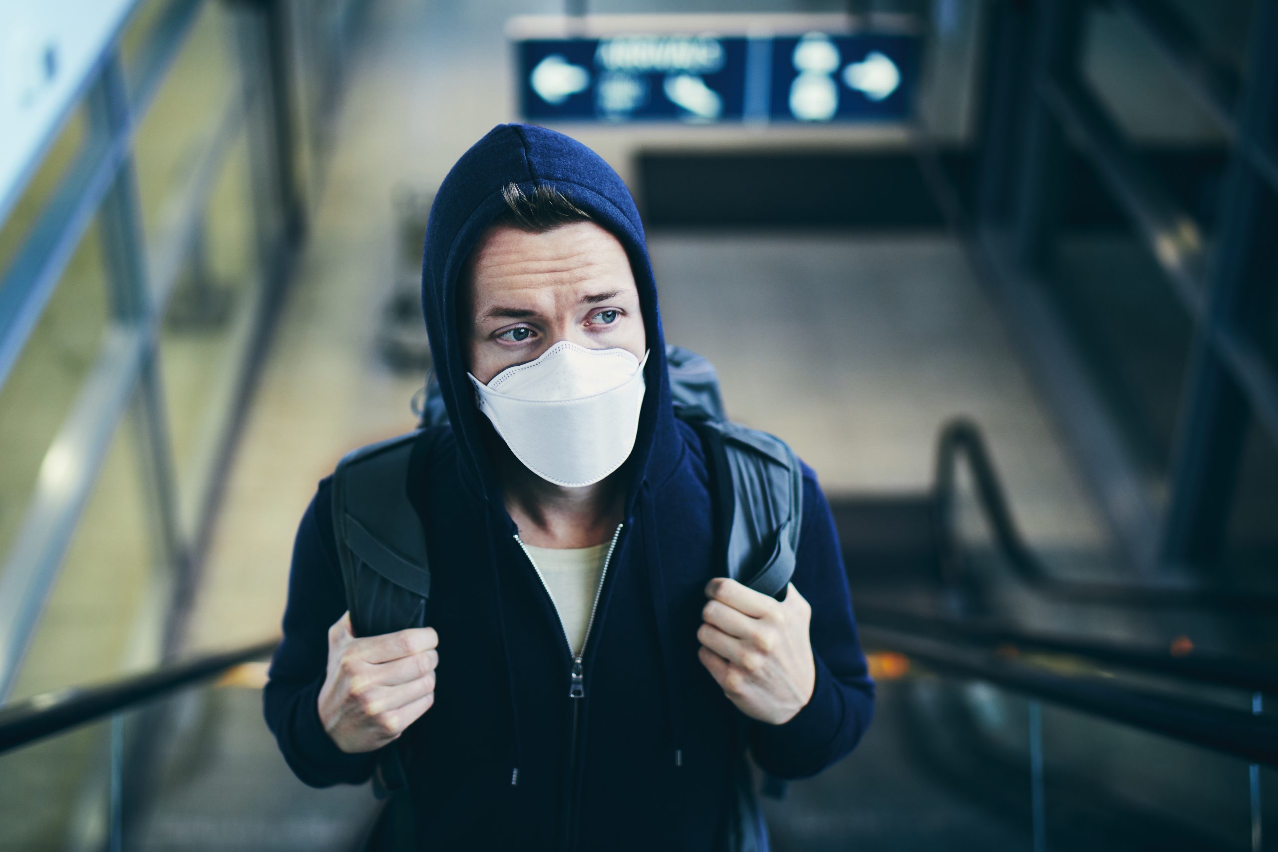 Man wearing face mask on escalator